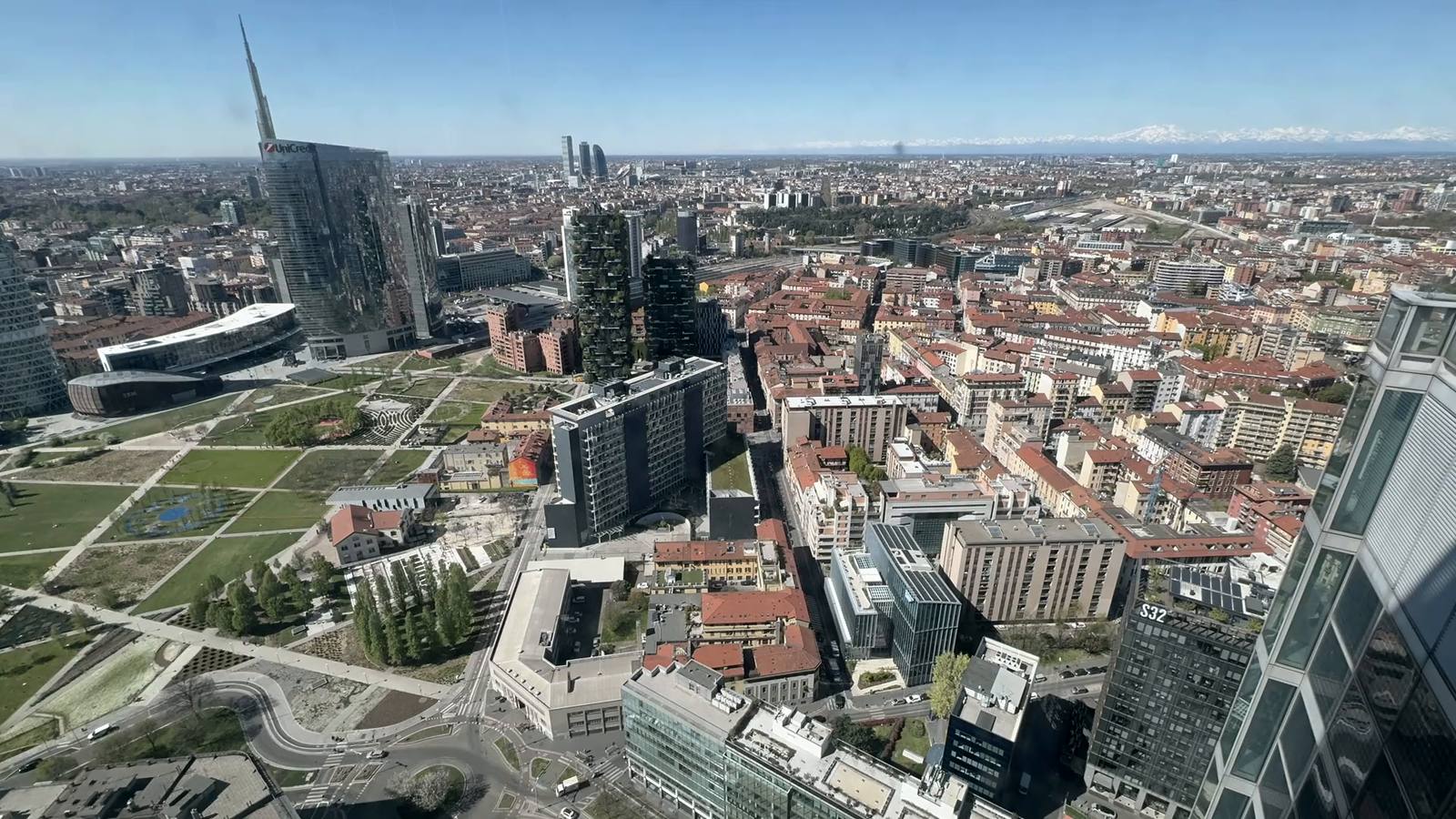 Veduta aerea di Milano con grattacieli, parchi e tetti in una giornata limpida