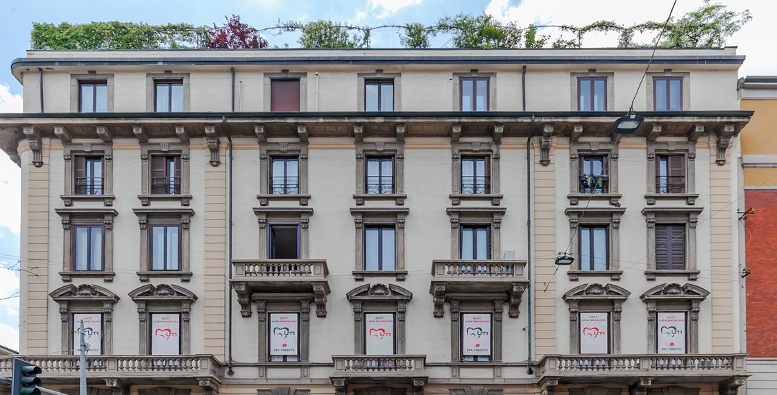 Facciata del palazzo in Piazza Lima 1 a Milano, con gli stendardi dello studio alle finestre